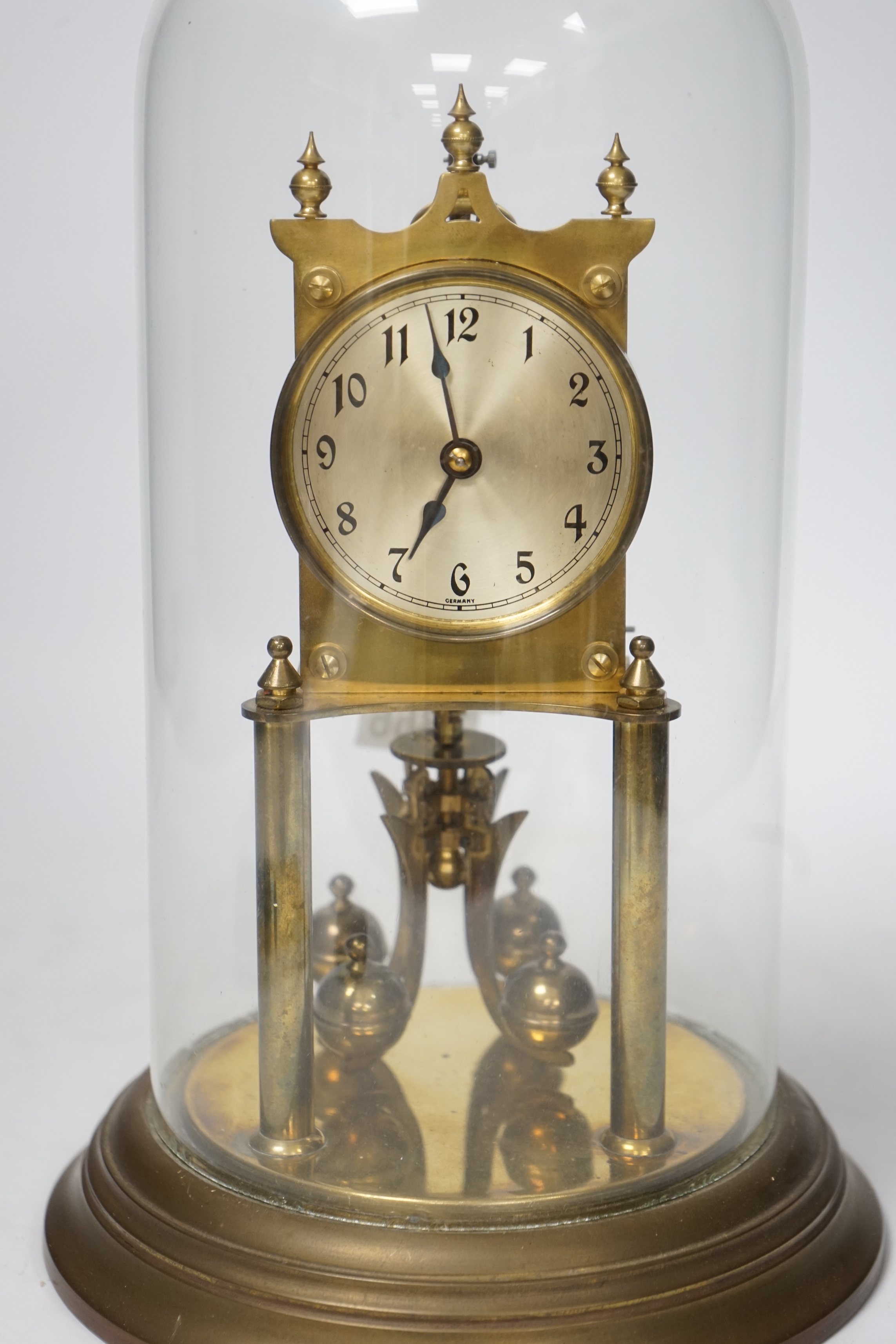 A 20th century German brass torsion pendulum clock under brass dome, 32cm high